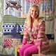 Portrait of Kit Kemp in front of a quilt made from Christopher Farr Cloth fabric.